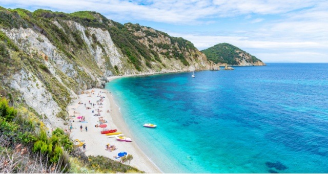 White cliffs and clear blue water at Sansone Beach in Elba, Italy