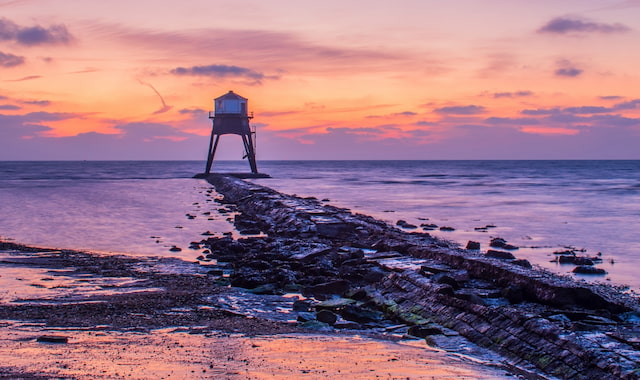 De lage vuurtoren van Dovercourt op het strand tijdens zonsondergang in Harwich, Engeland