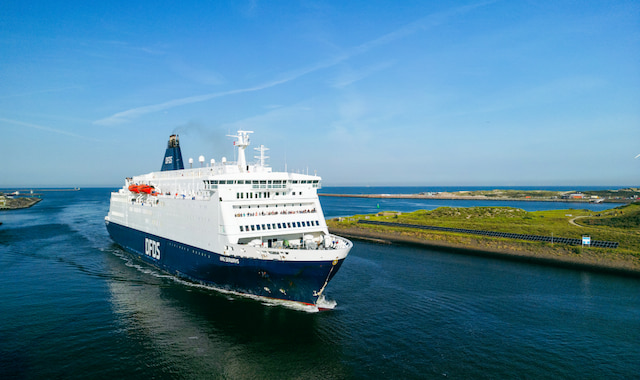 De grote wit-blauwe veerboot van DFDS King Seaways vaart over het water