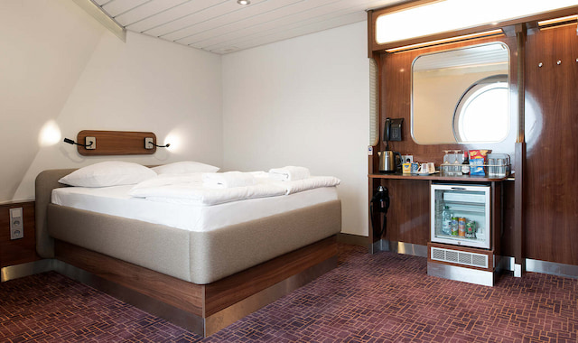Moderne en ruime premiumcabine met een tweepersoonsbed en een patrijspoort op een veerboot van Stena Line