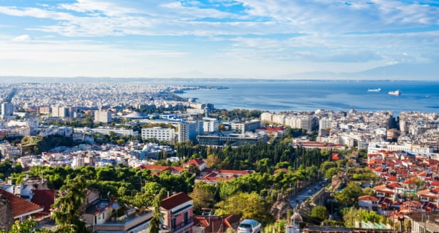 Panoramic view of the dense white buildings of Thessaloniki stretching toward the blue gulf in Greece