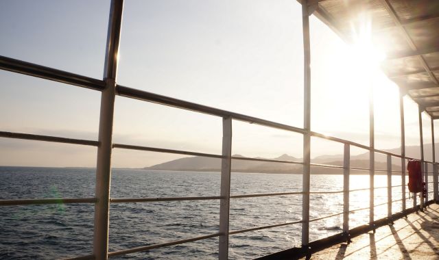View of the sea from out on deck on a ferryboat as the sun setes