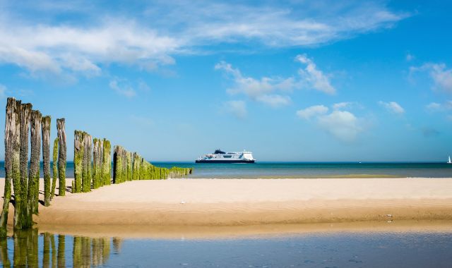 View of ferry from beach on the coast in northern France