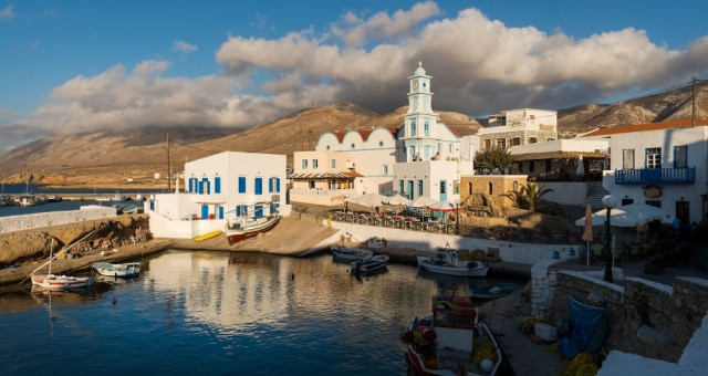 Traditional white houses and fishing boats in the harbor of Fri village in Kasos, Greece