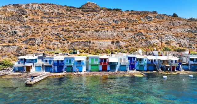 Row of colorful fisherman houses along the turquoise water in Klima, Milos, Greece