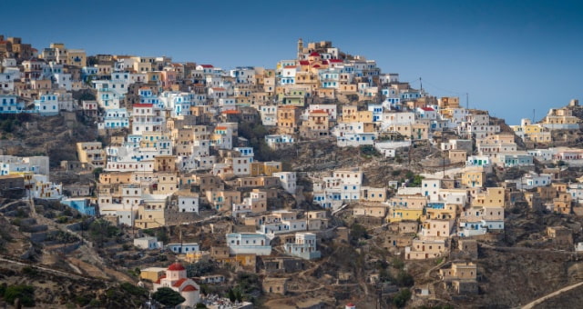 Colorful houses built on a steep mountain ridge in the traditional village of Olympos, Karpathos, Greece
