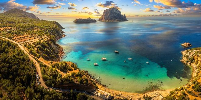 Cala d'Hort beach and the rocky islet of Es Vedrà at sunset in Ibiza, Spain