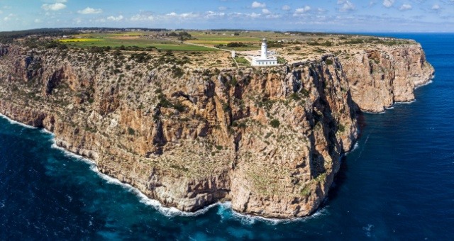 The white La Mola lighthouse on the high cliffs of Formentera, Spain