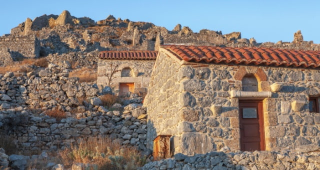 Stone ruins and small chapels of the Byzantine Castle of Chora under a clear sky in Kalymnos, Greece