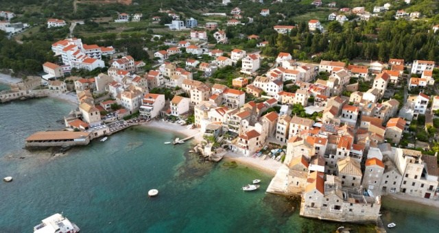Stone houses and fishing boats in the harbor of Komiža on Vis island, Croatia