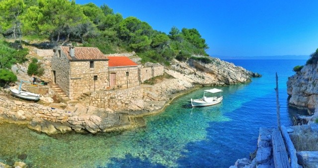 Secluded stone house and white boat in a turquoise bay on Lastovo island, Croatia