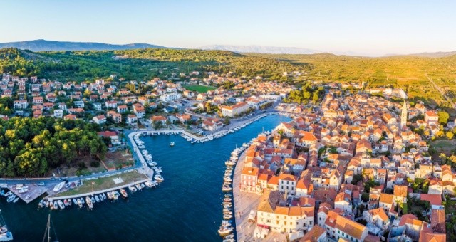 Harbor and red-roofed houses of Stari Grad on Hvar island at sunset, Croatia
