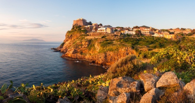 Fortress perched on a high cliff overlooking the sea in Capraia Isola, Italy