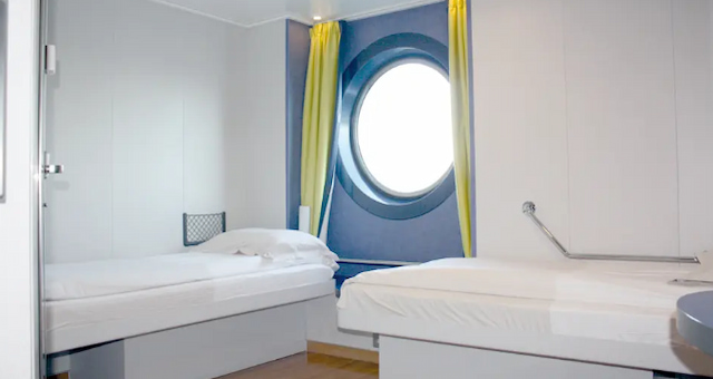 A wheelchair accessible ferry cabin with twin beds and a porthole window