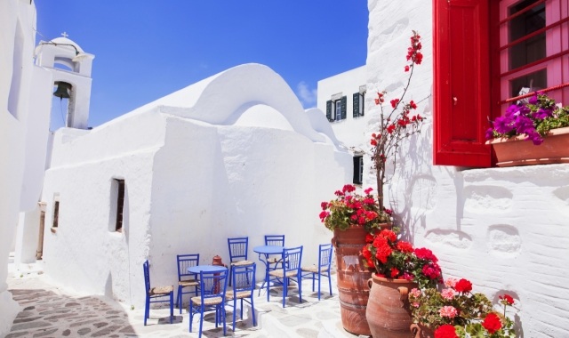 Cute Greek coffee shop surrounded by flowers and white-washed houses