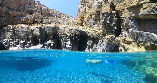 Diving in the clear waters of Amorgos from an impressive rocky cliff