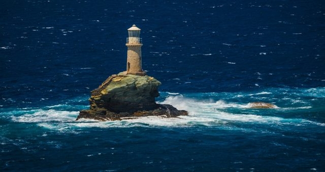 The Tourlitis lighthouse in the middle of the sea, near Andros’ Chora