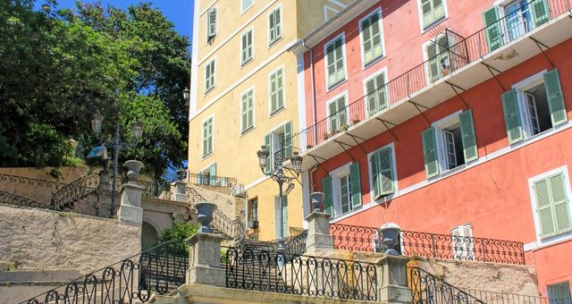 Una escalera frente a los edificios amarillos y naranjas del centro de Bastia