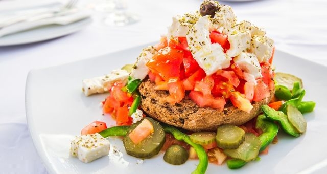 Un dakos servi avec un hachis de tomates et de fromage de blanc