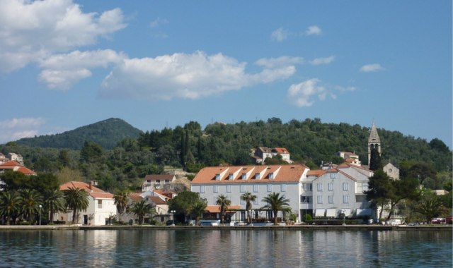 View of the Šipanska Luka waterfront with palm trees in Šipan, Croatia