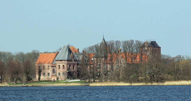 Aalholm Castle surrounded by water and trees, Denmark