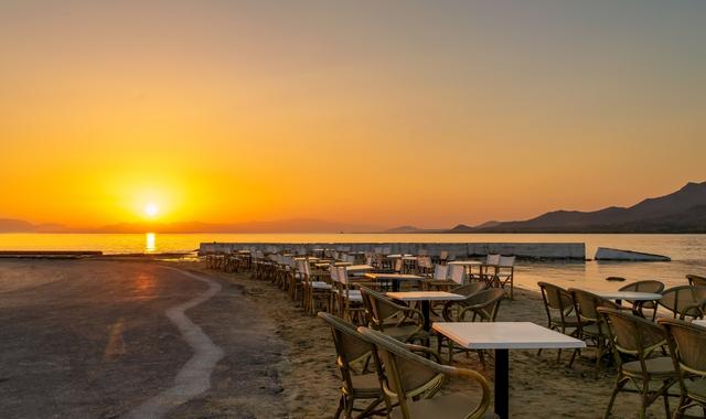 I tavolini di un ristorante il riva al mare durante il tramonto, a Elafonisos