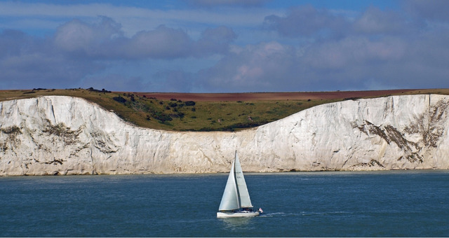 Ein Segelboot vor den weißen Klippen von Dover