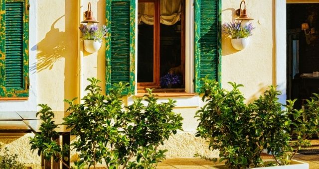 White house with green shutters in the historic center of Olbia