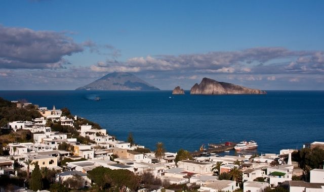 Ferry docked at the port of Panarea and view of the Aeolian archipelago