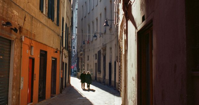 Two people walking down an alley in the center of Savona