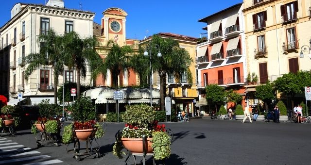 The Piazza Tasso in Sorrento, with palm trees and colorful buildings, Italy