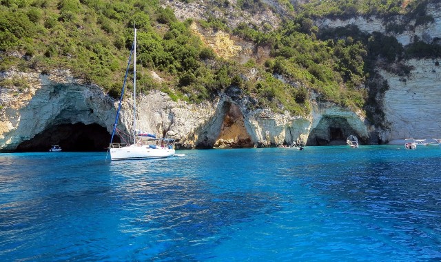 Eine Segelyacht kreuzt vor den Höhlen von Paxos