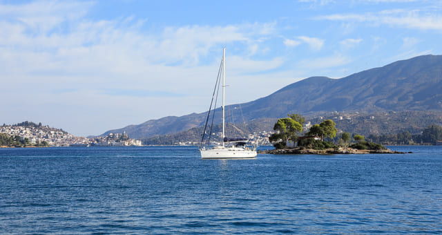 The small green islet of Daskalio in Poros, Greece