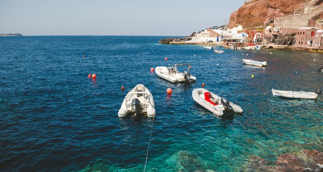 κόκκινα βράχια, κρυστάλλινα νερά, μικρή βάρκα, θάμνος, εισιτήρια για Σαντορίνη