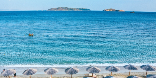 Ombrelloni davanti alle acque limpide della spiaggia di Koukounaries