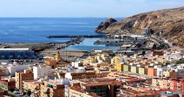 View to the port of Almería, nestled amidst the city's skyline and the vast expanse of the Mediterranean Sea, Spain