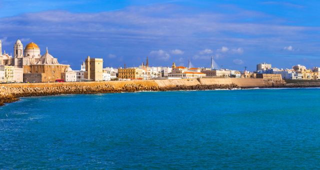 Vistas del paseo marítimo de Cádiz con edificios y catedral al fondo