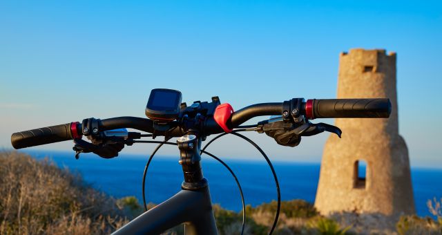 Ein Fahrrad vor dem Turm Gerro in Dénia, Spanien