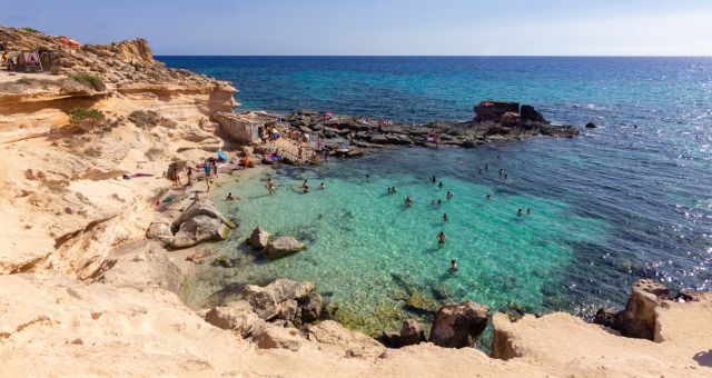 As águas azul-turquesa da enseada da Caló des Mort, em Formentera, Espanha