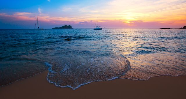 Le soleil se couche sur la plage de Cala Comte à Ibiza, Espagne