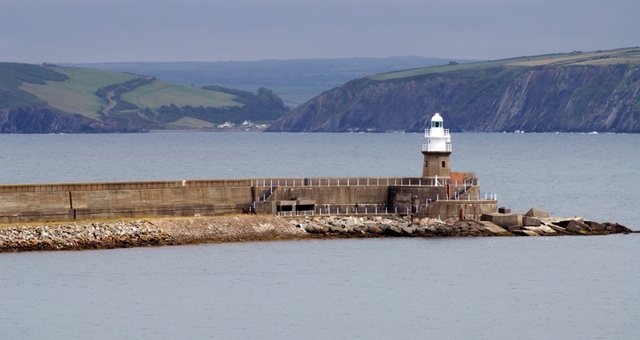 Lighthouse at the harbor of Fishguard and sea cliffs on the background, Pembrokeshire, Wales 